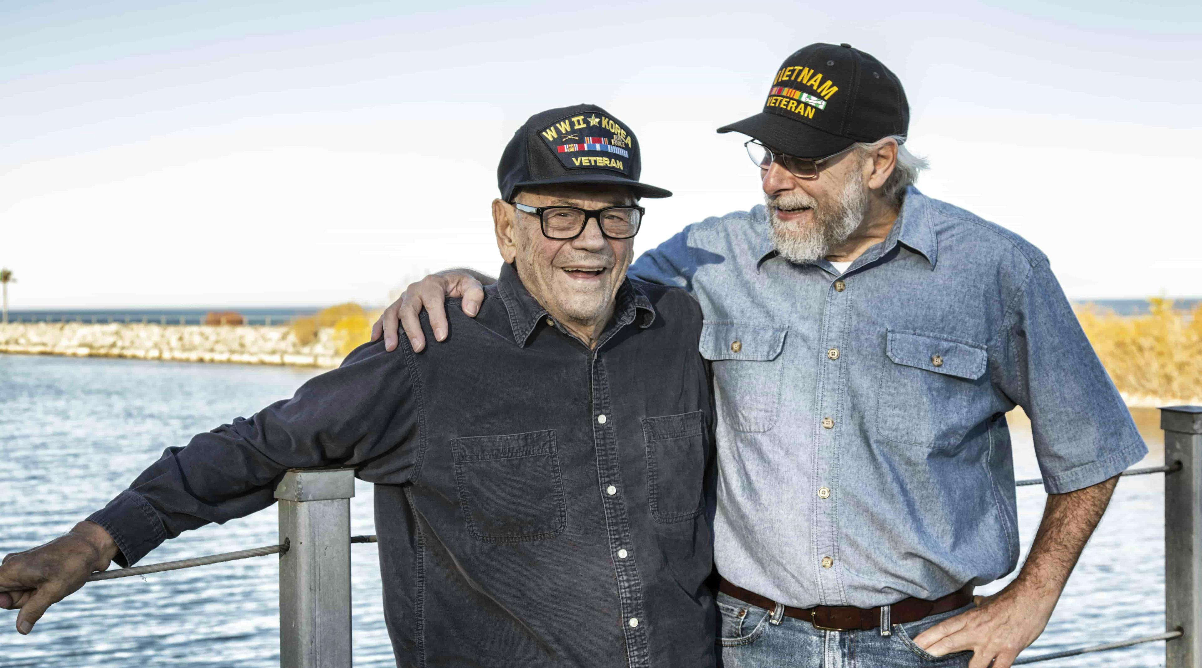 Veterans embracing by water\'s edge